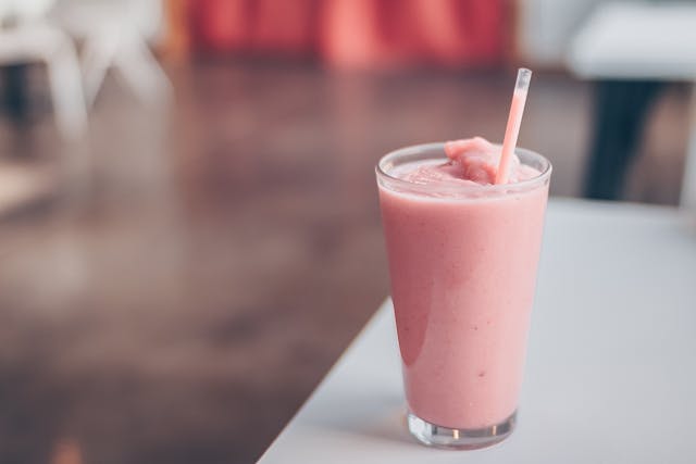 Refreshing pink smoothie in a transparent glass with fresh fruit blend